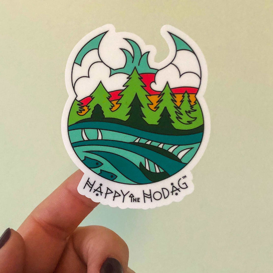 Sticker shaped like Happy the hod's head with colorful artwork of sky, trees, water and a Meshipeshu hiding in the waves with the text Happy the Hodag