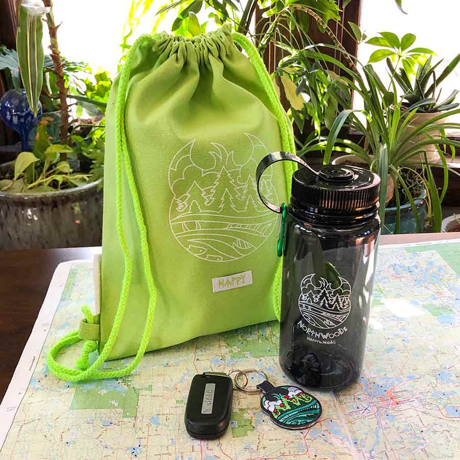 Lime green back pack, grey water bottle and colorful keychain sitting on a map.