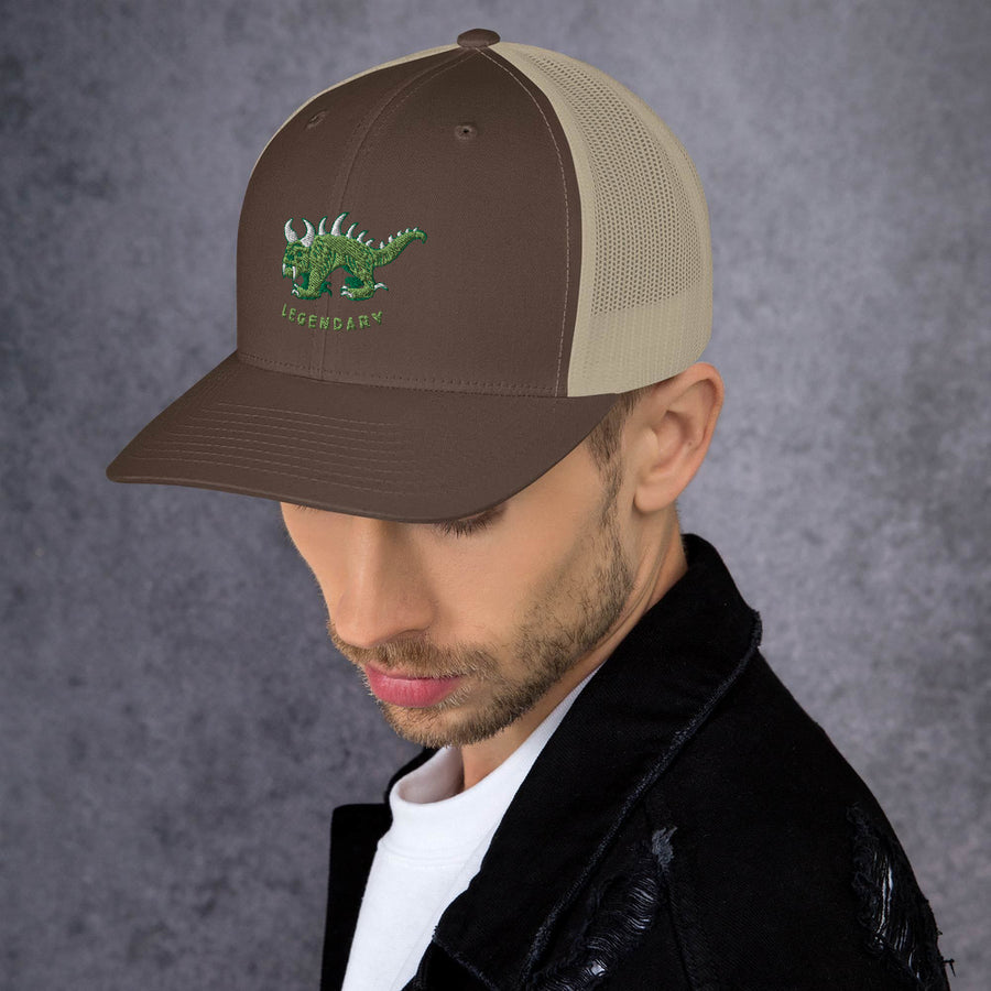 Brown and tan trucker cap, side view, with two tone green and white vintage embroidered Hodag with the word legendary underneath.